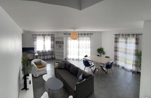 a living room with a couch and a table at Les Villas de Castel - villa "Les Muriers" in Castelmaurou