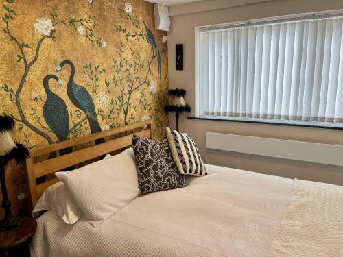 a bedroom with a bed and a wall with birds at Lovely independent 1-Bed Apartment in Freshwater in Freshwater