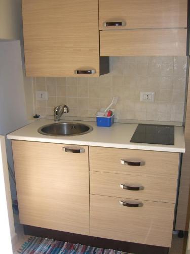 una cocina con fregadero y armarios de madera en Casa Marianna Short Lets, en Polignano a Mare
