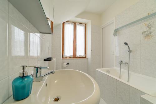 y baño blanco con lavabo y bañera. en Garda Doma, en Brenzone sul Garda