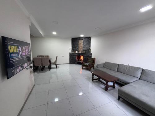 sala de estar con sofá y chimenea en Friendly House, en Akhaltsikhe