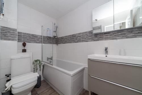 ein Badezimmer mit einer Badewanne, einem WC und einem Waschbecken in der Unterkunft The Peckham Collection in London