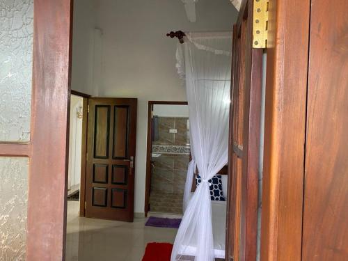 una puerta abierta con una cortina en una habitación en New Bimal Villa, en Bentota