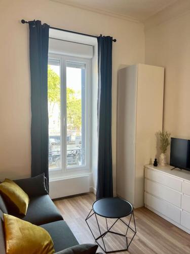 un salon avec un canapé et une fenêtre dans l'établissement Le Montpellier Rêvé, à Montpellier