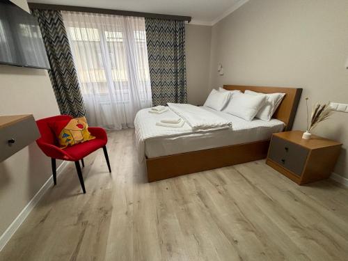 a bedroom with a bed and a red chair at RestArt Boutique Hotel in Dilijan