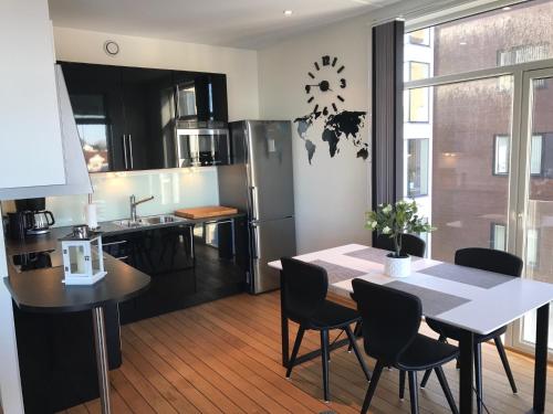 a kitchen and dining room with a table and chairs at Svolvær Havn Apartments in Svolvær
