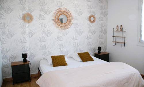 - une chambre avec 2 lits et un mur avec des feuilles dans l'établissement Ty Laouen - Maison proche plage et centre-ville, à Roscoff