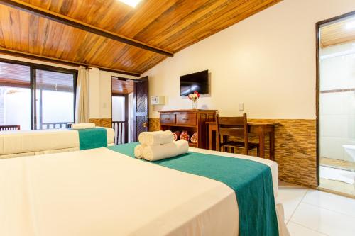 a bedroom with a bed and a dining room at Pousada Capitão Thomaz in Jericoacoara