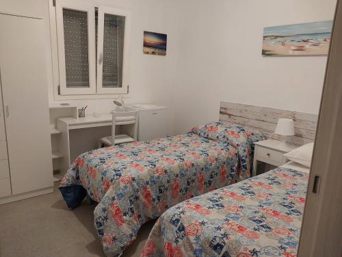 een slaapkamer met 2 bedden, een bureau en een raam bij NOTE DI MARE in Mola di Bari