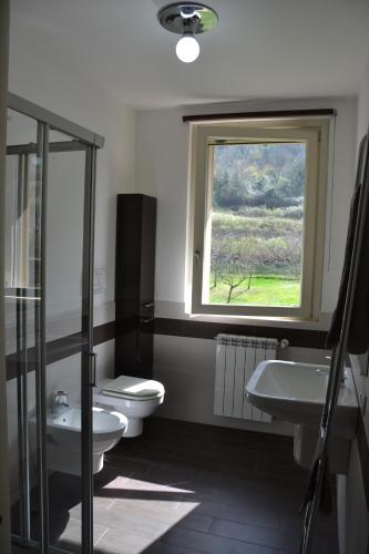 a bathroom with a toilet and a sink and a window at Dolce Casa Lago in Paratico