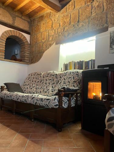 une chambre avec un lit dans une chambre avec une cheminée dans l'établissement L' Antico Lavatoio, à Pitigliano