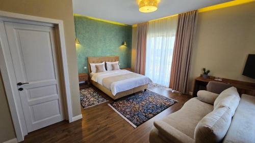 a hotel room with a bed and a couch at Hotel Măgura Jina in Jina