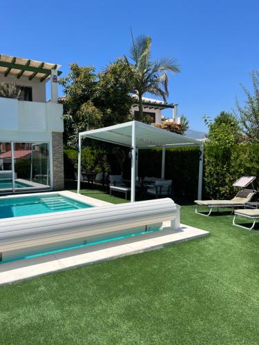 een villa met een zwembad en een huis bij Modern beachside townhouse w/ private pool in Marbella
