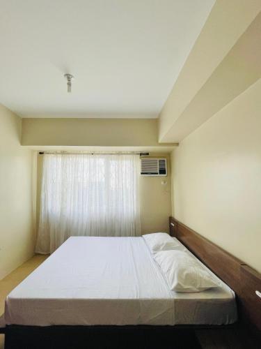 een bed in een kamer met een raam bij * *J2 Simple City Retreat in Iloilo City