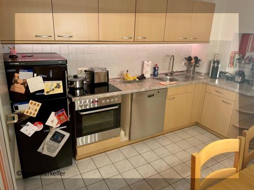 Schönes und ruhiges Privatzimmer mit französischem Balkon في ميونخ: مطبخ مع موقد ومغسلة وثلاجة