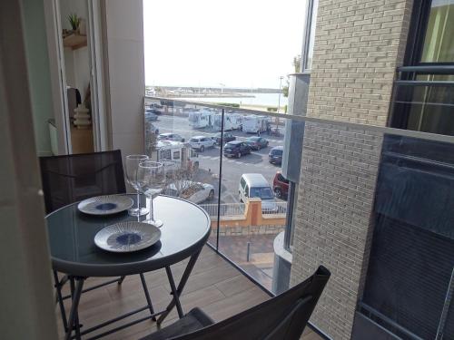 a table on a balcony with a view of a parking lot at Andmar Beach Apartamento in Peñíscola