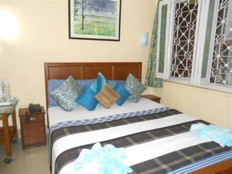 ein Schlafzimmer mit einem Bett mit blauen Kissen in der Unterkunft Zabardast Guest House in Buxoro