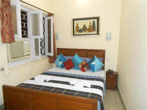 Schlafzimmer mit einem Bett mit blauen und roten Kissen in der Unterkunft Zabardast Guest House in Buxoro