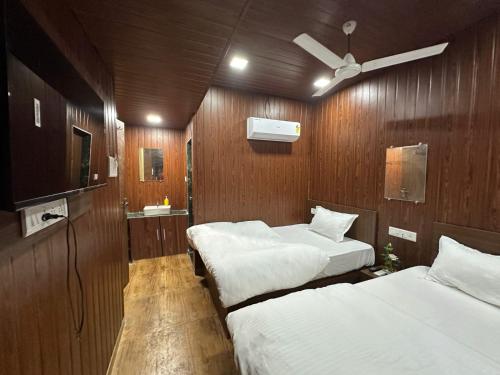 een slaapkamer met 2 bedden en een plafondventilator bij Hotel Grand Villa in Mumbai