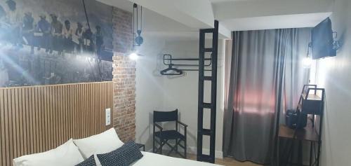 Habitación con dormitorio con cama y escalera. en Hostal Fronton, en Alcobendas
