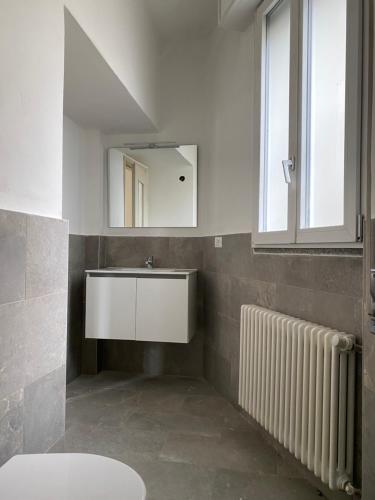ein Badezimmer mit einem Waschbecken, einem Spiegel und einem Heizkörper in der Unterkunft Maddalena Lake Como view terraces in Lezzeno
