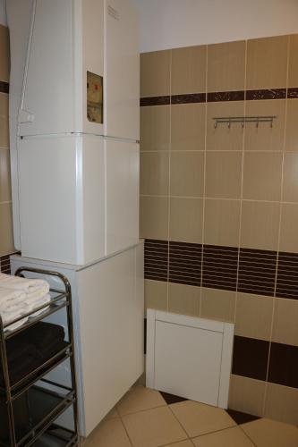 a small kitchen with a refrigerator and a table at Vila Pohoda - Apartmán s vonkajšou terasou a záhradou in Belonia