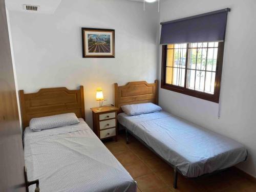 1 Schlafzimmer mit 2 Betten und einem Fenster in der Unterkunft Spacious 3 Bed Apartment in Senorio de Roda in Roda