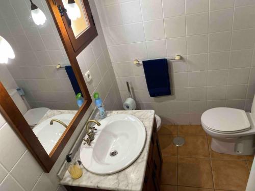 y baño con lavabo, aseo y espejo. en Spacious 3 Bed Apartment in Senorio de Roda, en Roda