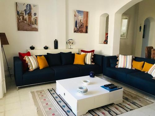a living room with a blue couch and a coffee table at Villa de Charme Adultes Only in Nabeul