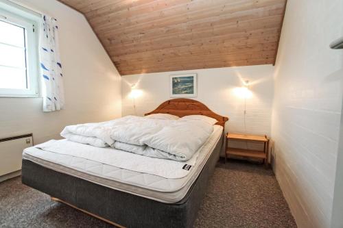 um quarto com uma cama grande num quarto em Thatched house with spa and pool by the sea - SJ67 em Harboør