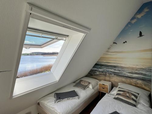 - une chambre avec une fenêtre et un lit dans une pièce dans l'établissement Haus mit Seeblick, gratis Nutzung vom AHOI Erlebnisbad und Sauna in Sellin - Fährhaus Sellin Nr 14, à Sellin