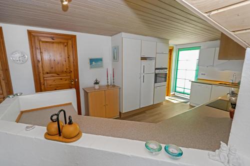uma cozinha com uma bancada e uma cozinha com uma bancada em Charming thatched stone house by the sea - SJ241 em Harboør
