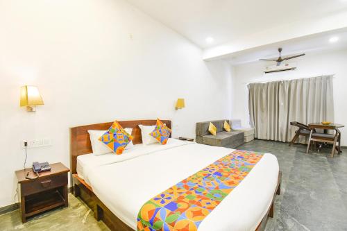 a bedroom with a large bed and a table at FabHotel Prime Kantara in Lonavala