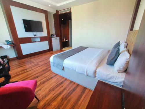 a hotel room with a bed and a flat screen tv at Hotel Akosha 