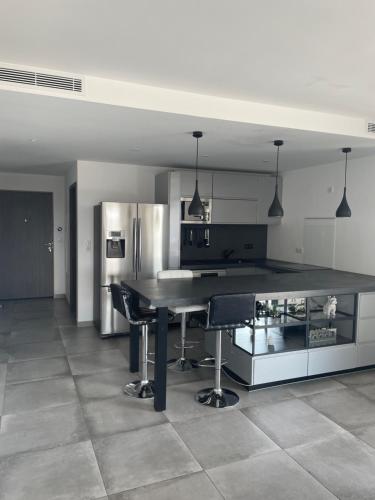 une cuisine avec une grande table noire et des chaises dans l'établissement Bel appartement spacieux à Porto-Vecchio, 10min à pieds du centre ville, à Porto-Vecchio
