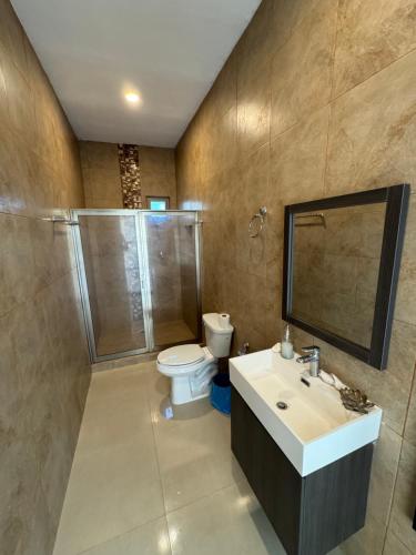 a bathroom with a toilet and a sink and a shower at Villas Mar Turquesa Cozumel in Cozumel