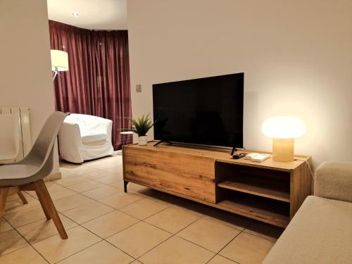 艾因薩的住宿－Sierco Apartamentos Ainsa，木质娱乐中心设有带平面电视的客厅。
