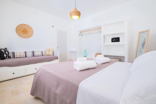 a white bedroom with two beds and a couch at Villa Zorro Luxury - Marina di Mancaversa in Marina di Mancaversa