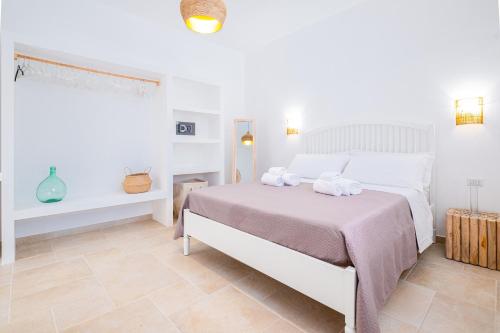 a bedroom with a bed with two towels on it at Villa Zorro Luxury - Marina di Mancaversa in Marina di Mancaversa