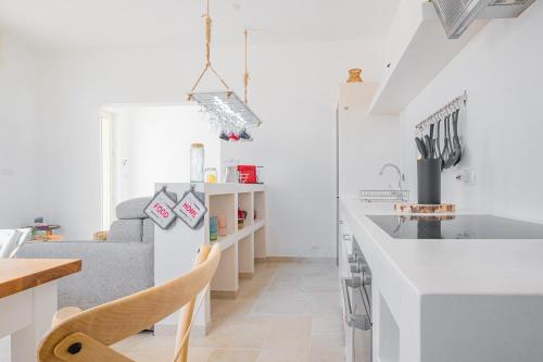 a kitchen and living room with a sink and a couch at Villa Zorro Luxury - Marina di Mancaversa in Marina di Mancaversa