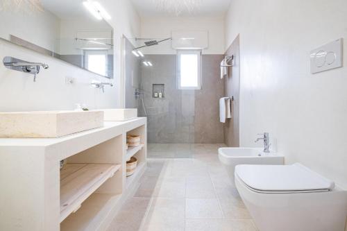 a white bathroom with a toilet and a sink at Villa Zorro Luxury - Marina di Mancaversa in Marina di Mancaversa