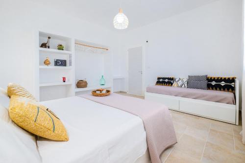 a white bedroom with a bed and a bench at Villa Zorro Luxury - Marina di Mancaversa in Marina di Mancaversa