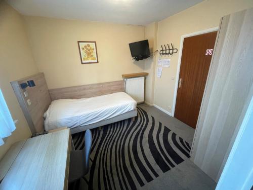 MortselにあるHotel Bristol Internationaalのベッドとラグ付きの小さな部屋です。