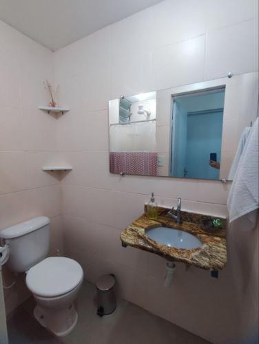 een badkamer met een toilet en een wastafel met een spiegel bij Apartamento em condomínio fechado na Farolândia in Aracaju