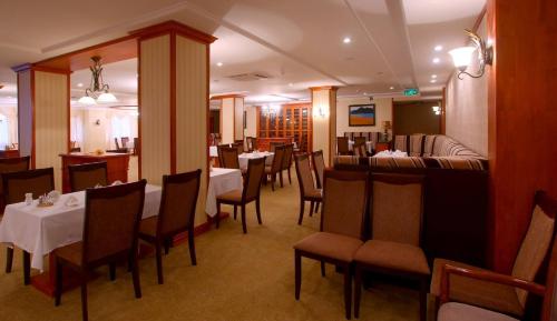 a dining room with tables and chairs in a restaurant at Buudai hotel in Darkhan