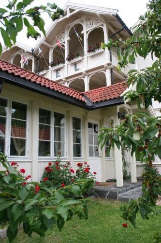 a large white house with flowers in front of it at Seljord Hotel - Unike Hoteller in Seljord