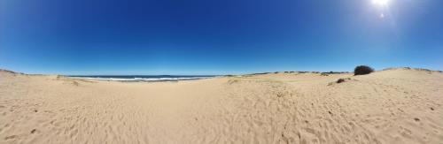 una duna de arena con el océano en el fondo en Aroma de mar en Sauce de Portezuelo