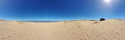 a sand dune with the ocean in the background at Aroma de mar casas en alquiler vacacional con hermosa piscina in Sauce de Portezuelo