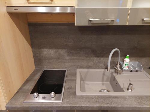 a kitchen counter top with a sink and a sink at BURSZTYNOWO Domy z saunami i jakuzzi in Ostrowo