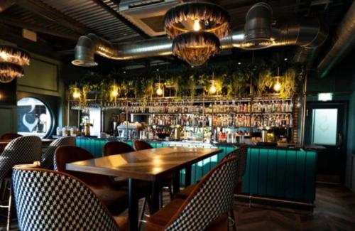 un restaurante con una mesa de madera y un bar en Shells Breaks Tattershall Lakes Shearwater 27, en Tattershall
